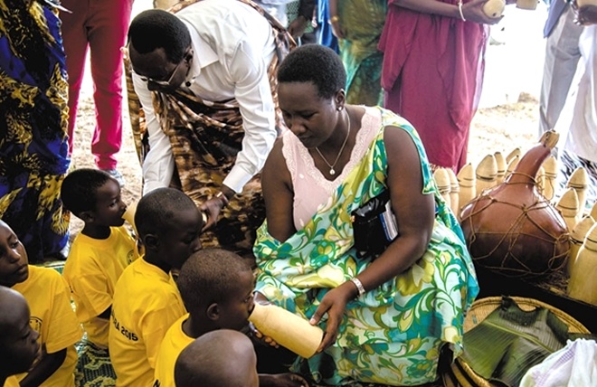 Bernard Makuza the Rwanda Senate President feeding children with milk during the national Umuganura day -a traditional cultural event that used to bring communities together to share seasonal agricultural produce.
