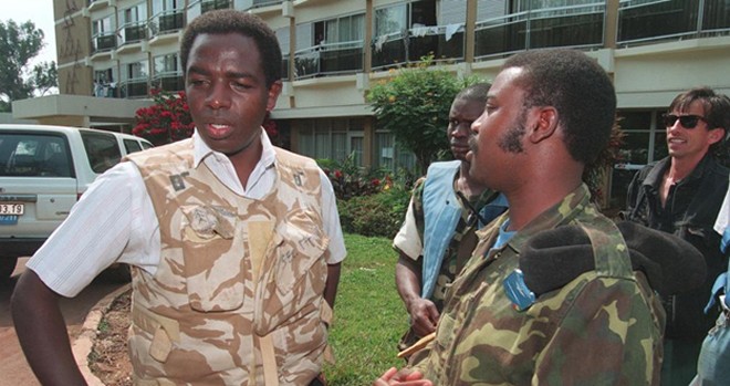  Father Wenscelas Munyeshyaka(L) surrounded by Rwandan soldiers, the ex-far 