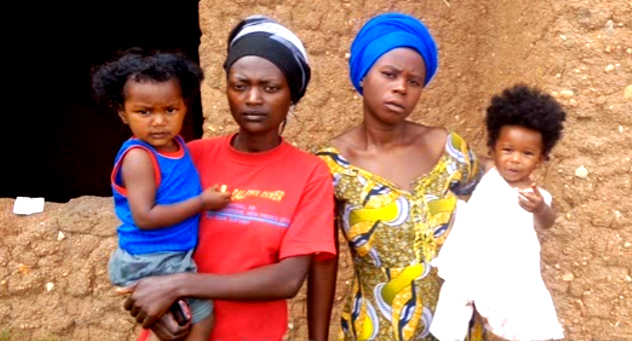 Two mothers holding their children. Their fathers are foreigners working with construction companies