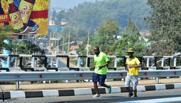 Kigali residents Jogging past an old billboard 